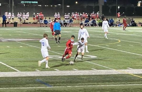 Brophy's Alejandro Hernandez-Guzman (red jersey, center) receives the ball and runs by a Sandra Day O'Connor defender. Feb. 19, 2021.