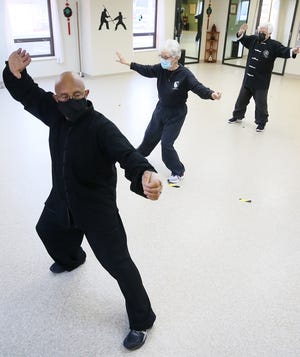 Gary Harris owner and operator of the Center for Body-Mind Harmony, front, leads a class in tai chi in Cuyahoga Falls on Tuesday Feb. 23, 2021.