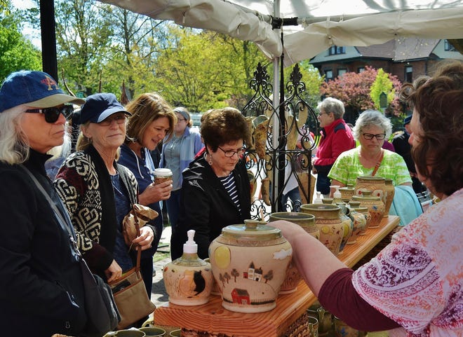 Shoppers explore artwork at Tulip Time's Artisan Market. The market will is taking place online this year with 75 vendors, and has been a success so far according to the festival.