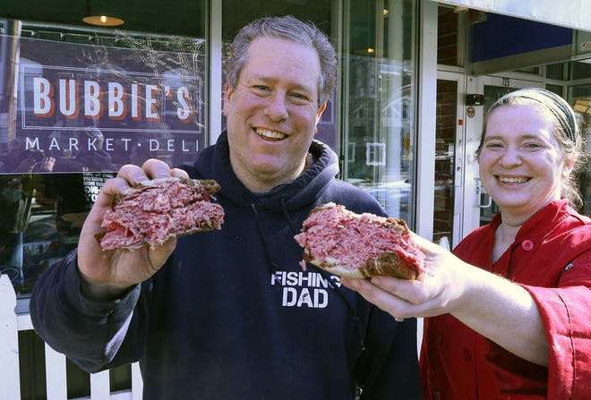 Co-owners Jeffrey Ingber and Freda Ronkin show off a corned beef sandwich that will be available with other deli items Sunday at the opening of Bubbie's Market and Deli in Providence.