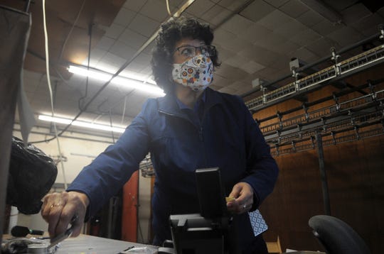 Twin Oaks Cleaners owner Theresa Sanchez picks up items from her desk while cleaning out the business Feb. 26, 2021 before it closes.