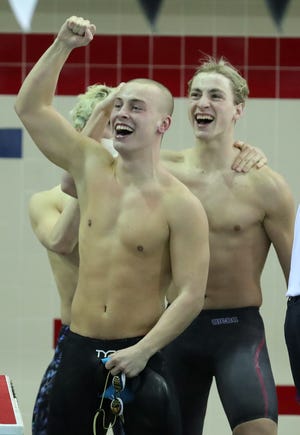 Members of the Lexington 200-yard medley relay team celebrate after placing first during the OHSAA Division II Swimming and Diving Championships at C.T. Branin Natatorium on Thursday, Feb. 25, 2021 in Canton.