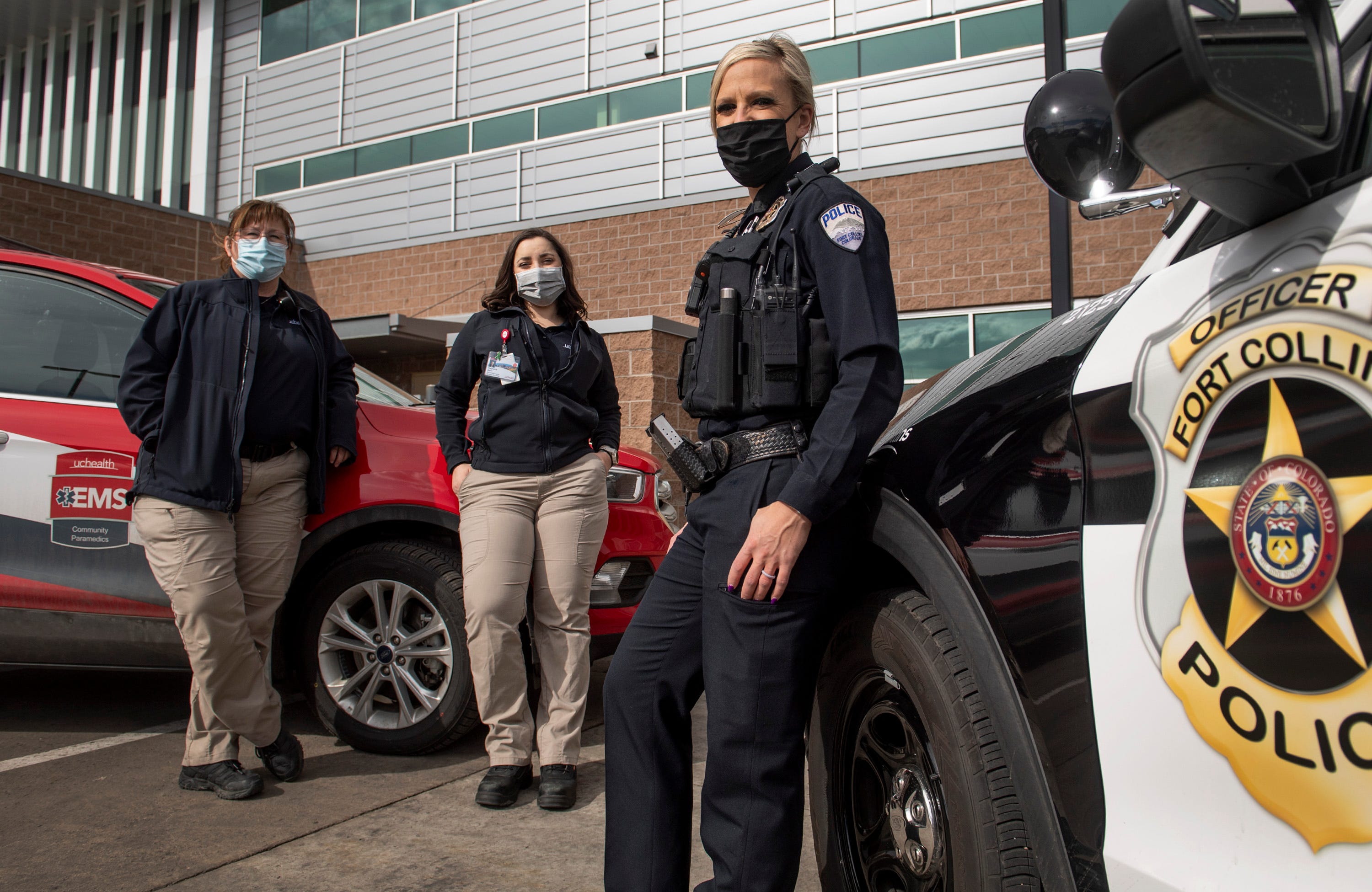 Community Paramedic Julie Bower, left, Community Programs Coordinator and co-responder Stephanie Booco, center, and Fort Collins police officer Annie Hill stand alongside their vehicles outside Fort Collins Police Services in Fort Collins. The women are among those working in the new Mental Health Response Team unit, the third version of the Fort Collins co-responder program first launched in July 2018.