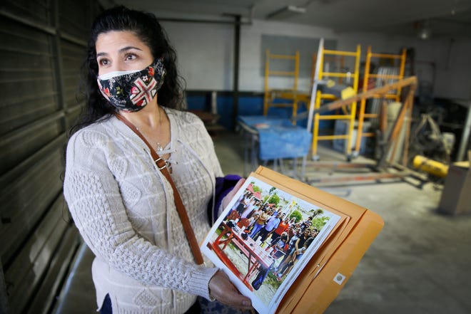 Margarita Dominguez looks at the last photo she has of all her family together during a visit to Superior Body & Paint Shop on Wednesday, Feb. 24, 2021, in El Paso. Dominguez's father Alfredo Medina, 74, died of COVID-19 on Nov. 25, 2020, and her brother Julio Medina, 47, died of COVID-19 on Dec. 9, 2020.