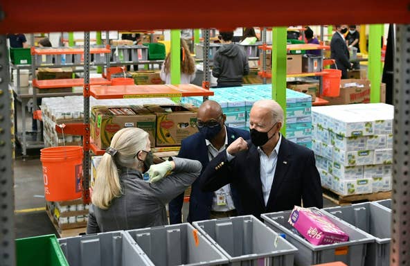 US President Joe Biden elbow bumps a volunteer during a visit at the Houston Food Bank in Houston, Texas on February 26, 2021. Biden is visiting Houston, Texas following severe winter storms which left much of the state without electricity for days.