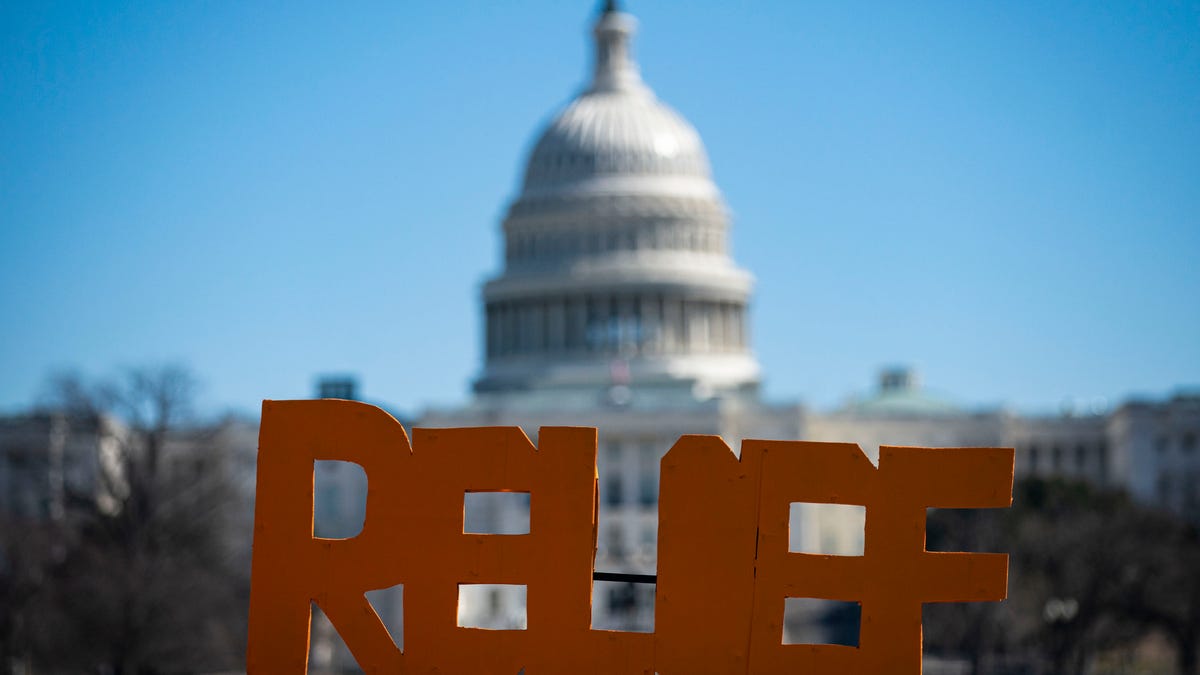The U.S. Capitol is seen behind a sign during a demonstration in support of COVID-19 relief, organized by Shutdown DC, on the National Mall,  on February 25, 2021 in Washington, D.C.