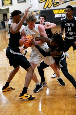 Richmond Hill's Leighton Finley battles for control of the ball with North Atlanta's Montavious Myrick, left, and Khaman Olivaccee during Friday night's GHSA Class 6A second-round state playoff game at Richmond Hill.