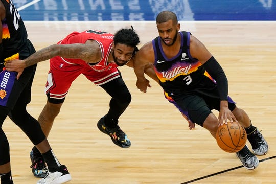 Phoenix Suns guard Chris Paul, right, drives against Chicago Bulls guard Coby White during the first half of an NBA basketball game in Chicago, Friday, Feb. 26, 2021. (AP Photo/Nam Y. Huh)