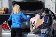 Kristen Nordquist (left) and a fellow volunteer put baby supplies into a mother's car on Feb. 27, 2021, at The Phoenix VA Health Care System.