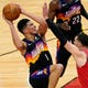Phoenix Suns guard Devin Booker, left, drives to the basket against Chicago Bulls guard Zach LaVine, center, and forward Luke Kornet during the first half of an NBA basketball game in Chicago, Friday, Feb. 26, 2021. (AP Photo/Nam Y. Huh).