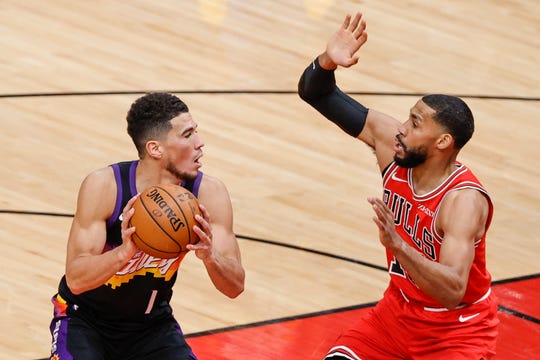 Feb 26, 2021; Chicago, Illinois, USA; Phoenix Suns guard Devin Booker (1) is defended by Chicago Bulls guard Garrett Temple (17) during the first half of an NBA game at United Center. Mandatory Credit: Kamil Krzaczynski-USA TODAY Sports