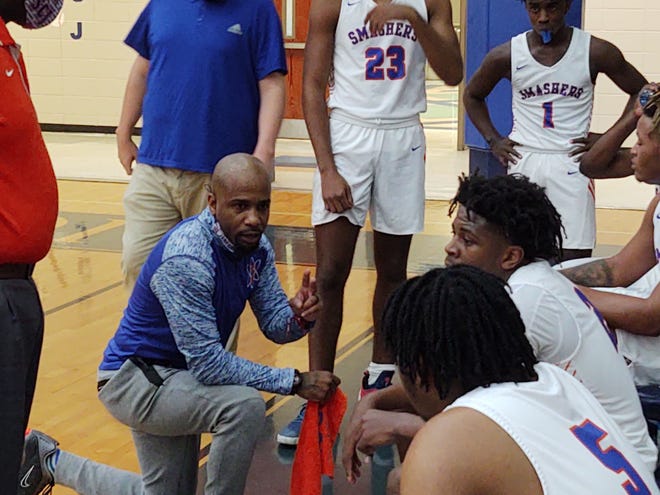 Johnson boys basketball coach Chuck Campbell talks with his players during a timeout during the GHSA Class 3A second-round playoff game against Long County on Saturday night at Johnson High. The host Atom Smashers won 75-43.