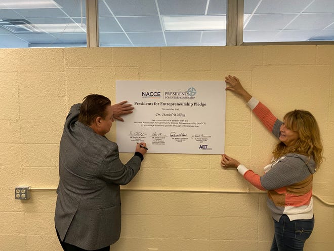 Victor Valley College President/Superintendent Dr. Daniel Walden signs the Presidents for Entrepreneurship Pledge with support from his executive assistant, Michelle Painter.