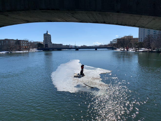 In this image shared by Rockford Fire Department on Twitter, two men float down the Rock River on a block of ice on Monday, March 1, 2021. The fire department mobilized its boats for a water rescue.