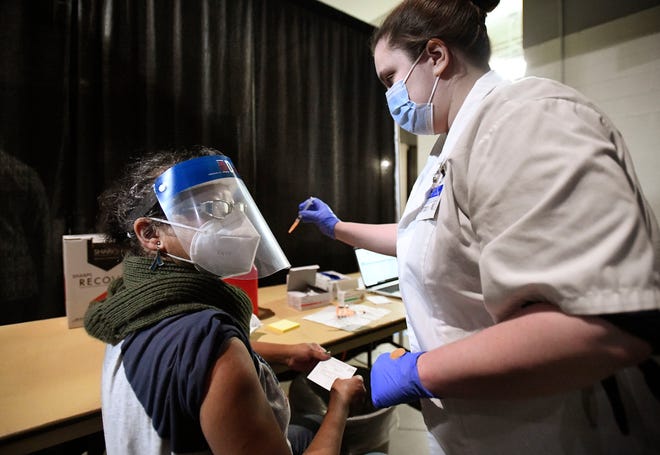 L'aiutante degli insegnanti del distretto scolastico di Berkeley, Sylvia Boyd di Detroit, riceve un vaccino COVID-19 dalla farmacia Meijer Brittany Wilkinson.  Meijer ha ospitato una clinica per vaccini al Ford Field esclusivamente per educatori e personale educativo a Detroit il 1 ° marzo 2021.