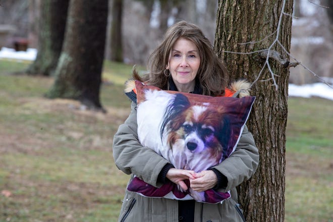 Rhonda Bomwell, of Somerset, N.J., holds a pillow Monday, March 1, 2021, with the image of Pierre, her 9-year-old Papillon, that died June 1, 2020, from side effects of wearing a popular flea and tick collar for pets.