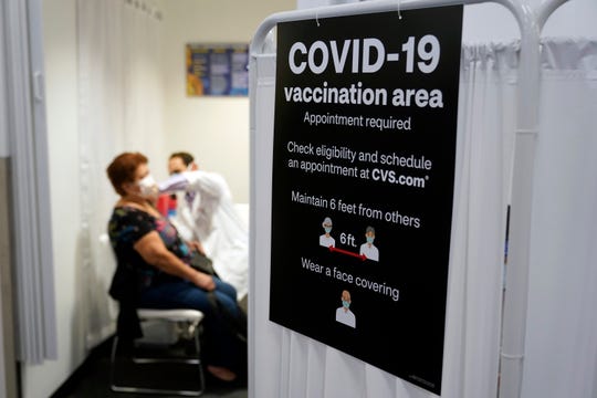 A patient receives a shot of the Moderna COVID-19 vaccine at a CVS Pharmacy store in Los Angeles on Monday.