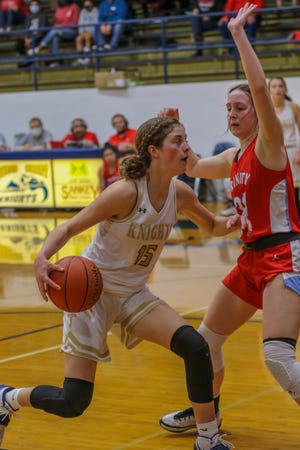 Sacred Heart's Avery Eshleman (15) drives to the basket while being defended by Hutchinson Trinity's Becca Hammersmith (30) during their game in March at Sacred Heart.
