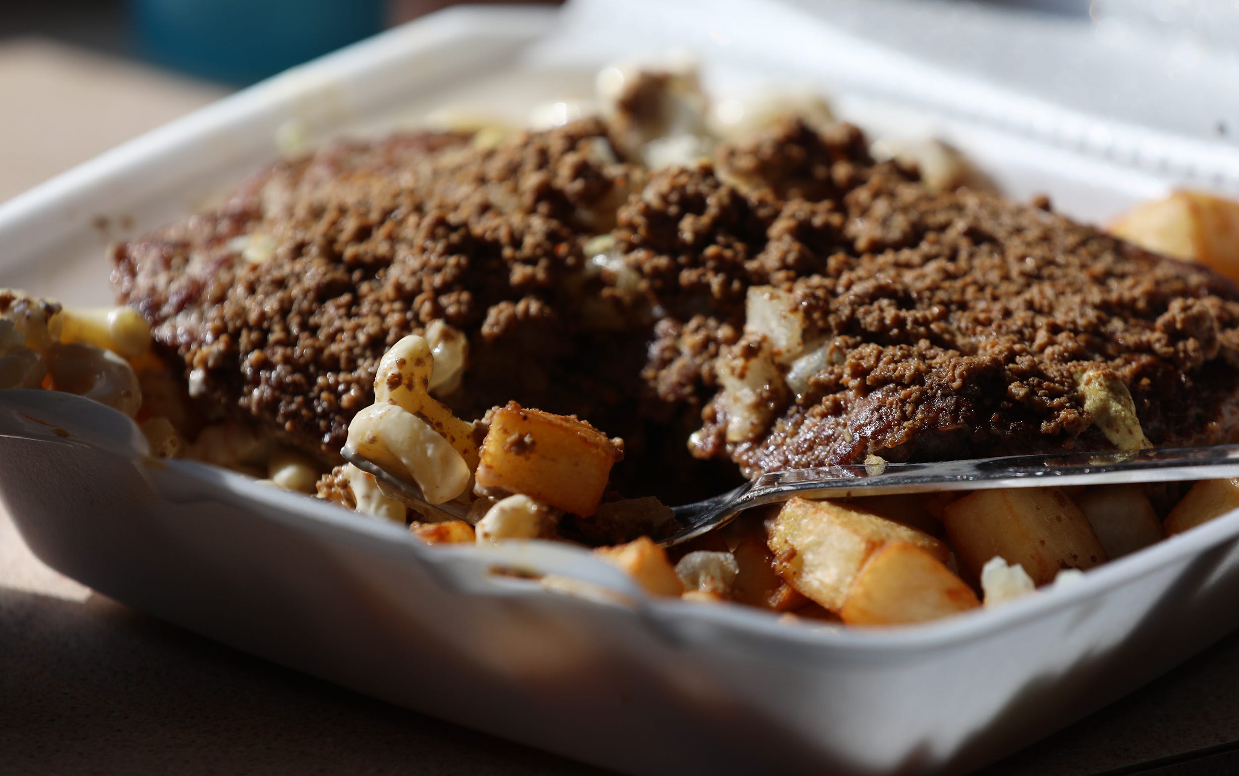 Nick Tahou Hots is famous for inventing the Garbage Plate. This is a Hamburger Garbage Plate with everything, including two hamburgers, hot sauce, macaroni salad, home fries, onions and mustard.