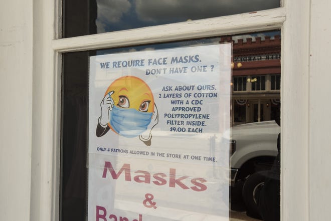 A business in Bastrop has a sign explaining that it requires customers to wear face coverings in the establishment. Gov. Greg Abbott on Tuesday announced an order lifting a mask mandate effective March 10. Business may continue to require customers to wear face masks, Abbott said.