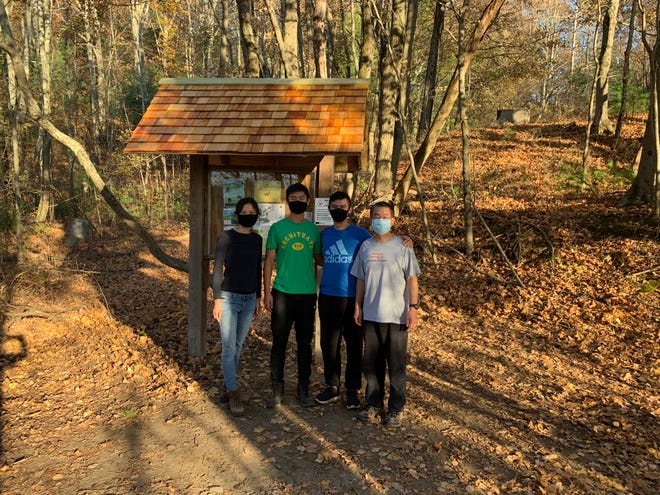 Andrew Zhao (second from left) and his (from left to right) mother Qing Zhong, brother Nathan Zhao and father Zhong Zhao in front of his completed Eagle Project at Round Hill near the Lincoln Meadows Conservation in Sudbury.