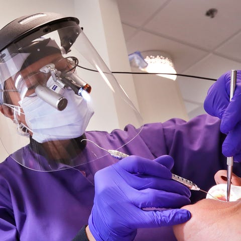 A dentist examines a patient.