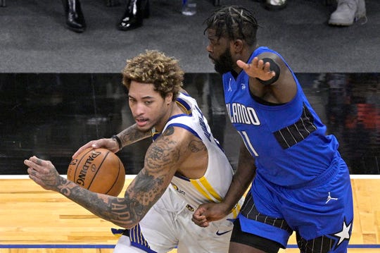 Golden State Warriors guard Kelly Oubre Jr., left, drives to the basket in front of Orlando Magic forward James Ennis III (11) during the first half of an NBA basketball game, Friday, Feb. 19, 2021, in Orlando, Fla. (AP Photo/Phelan M. Ebenhack).
