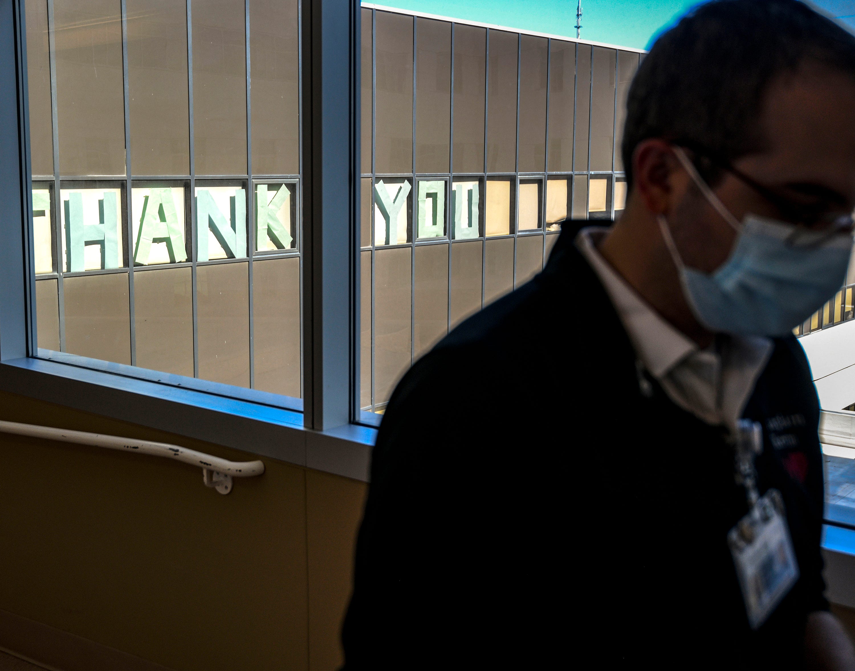 Each day at Providence Holy Cross Medical Center in Los Angeles, Chaplin Kevin Deegan passes through a hallway filled with glass windows to get to the COVID unit, as he does pictured on Friday, Feb. 12, 2021. Outside the windows is a message thanking hospital staff for their work.