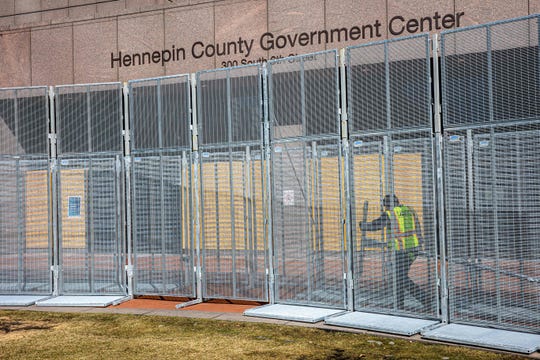 A worker installs security fencing at the Hennepin County Government Headquarters in Minneapolis, Minnesota, on March 3, 2021. Security measures are being increased and expected to see more police and National Guard soldiers in downtown Minneapolis before jury selection begins at the trial of former Minneapolis Police officer Derek Chauvin in George Floyd's death on March 8. 