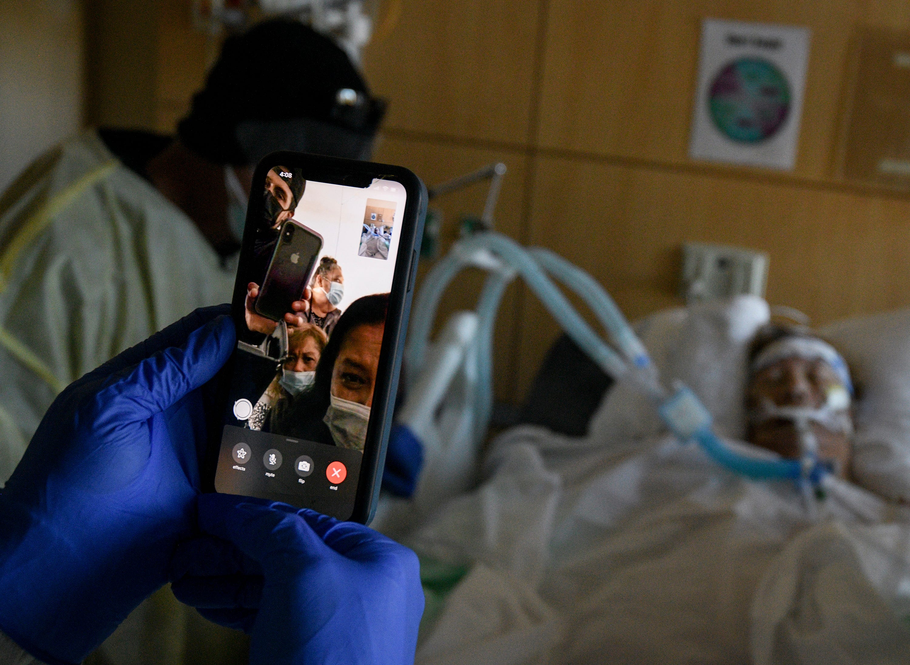 Members of the Dominguez family talk to Etelvina Dominguez, 78, via a smartphone on Friday, Feb. 12, 2021, at Providence Holy Cross Medical Center in Los Angeles. Due to the COVID-19 pandemic, family visits are allowed only in special cases, but they can visit by video calls. Etelvina spent more than 30 days in the hospital battling COVID-19 and passed away a day after her eldest son and husband visited her.