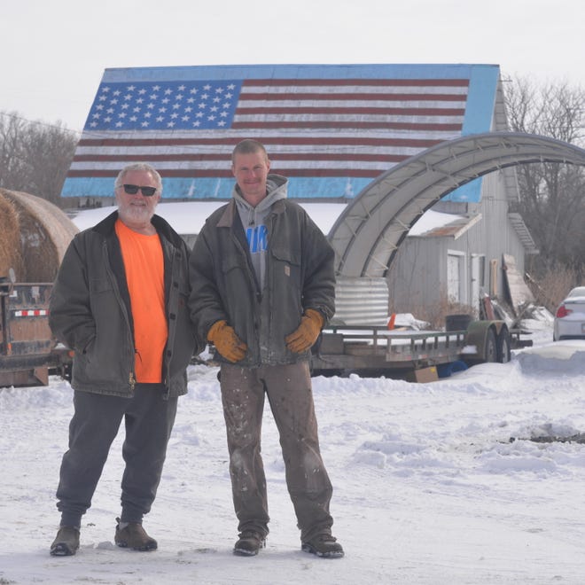 Randy Stewart, left, and his son, Austin, lacking a flag pole, painted the American flag on their barn roof.