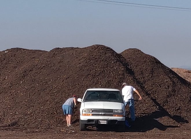 Residents picking up free composted mulch at the Foothills Landfill Composting Facility. Bring a pickup truck or some buckets, a shovel, and get as much as needed.