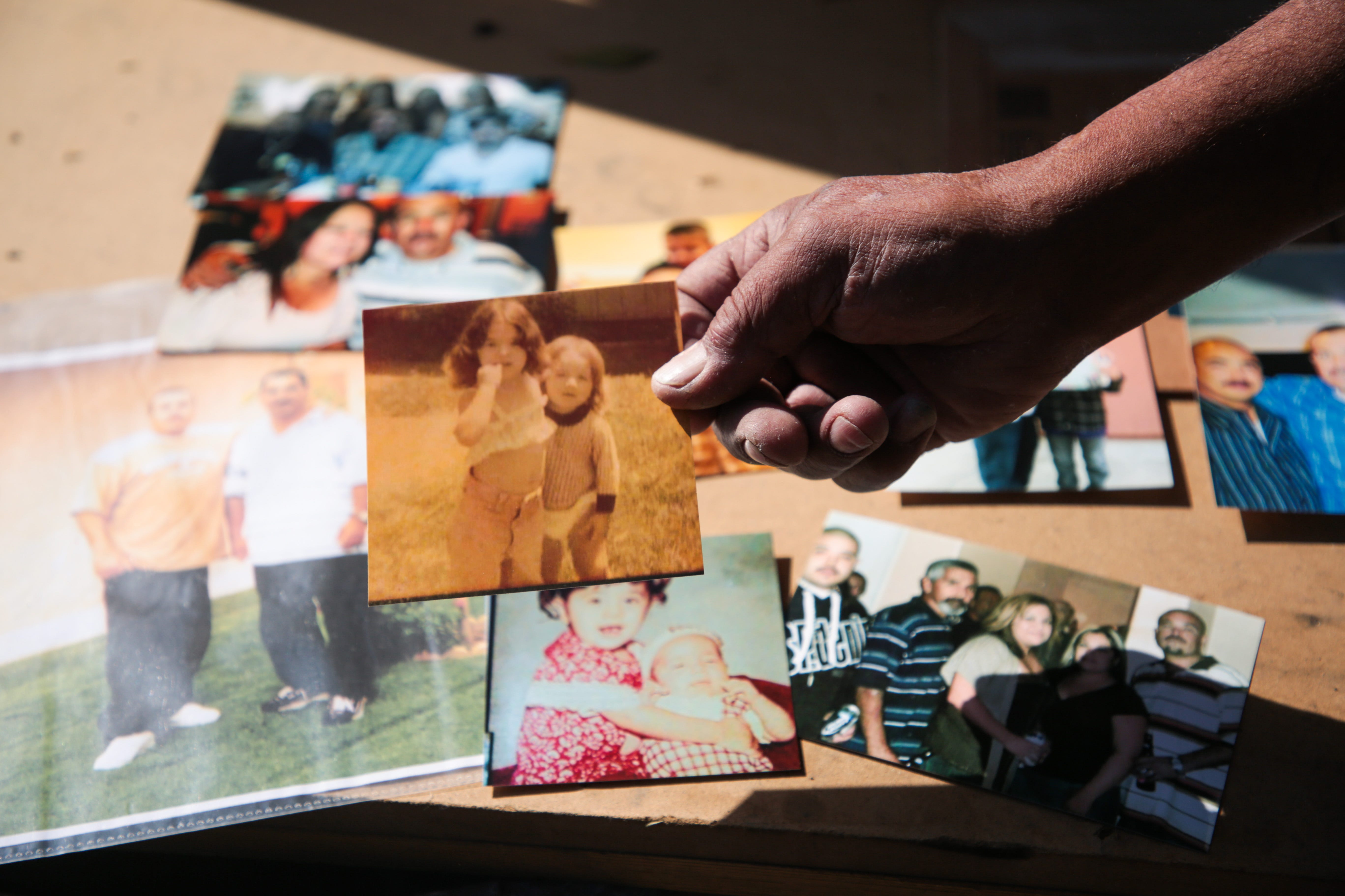 Luis Carlos Morin Sr. goes through photos of his son, Luis Carlos Morin Jr., right, at his home in Coachella on Feb. 25, 2021. Former Riverside County Sheriff's Deputy Oscar Rodriguez is being prosecuted for fatally shooting Luis Morin Jr. in 2014.