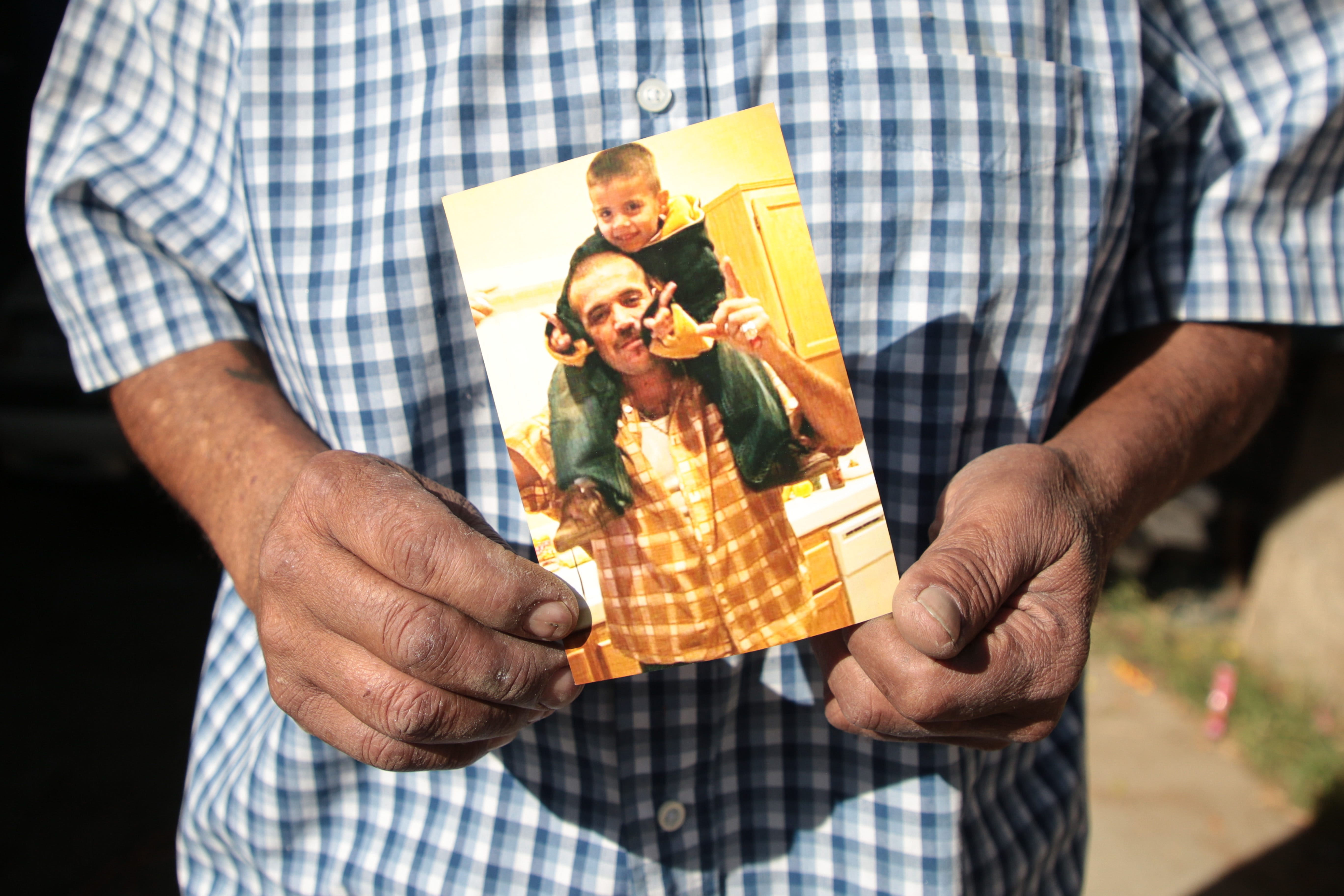 Luis Carlos Morin Sr. holds a photo of his son, Luis Carlos Morin Jr., and his grandson at his home in Coachella, on Feb. 25, 2021. Former Riverside County Sheriff's Deputy Oscar Rodriguez is accused of fatally shooting Luis Morin Jr. in 2014.