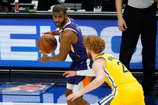 Phoenix Suns guard Chris Paul is defended by Golden State Warriors guard Nico Mannion during the second half of an NBA basketball game Thursday, March 4, 2021, in Phoenix. (AP Photo/Rick Scuteri).