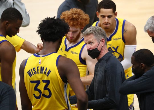 Mar 4, 2021; Phoenix, Arizona, USA; Golden State Warriors head coach Steve Kerr (right) talks with center James Wiseman (33) in the huddle against the Phoenix Suns in the second half at Phoenix Suns Arena. Mandatory Credit: Mark J. Rebilas-USA TODAY Sports