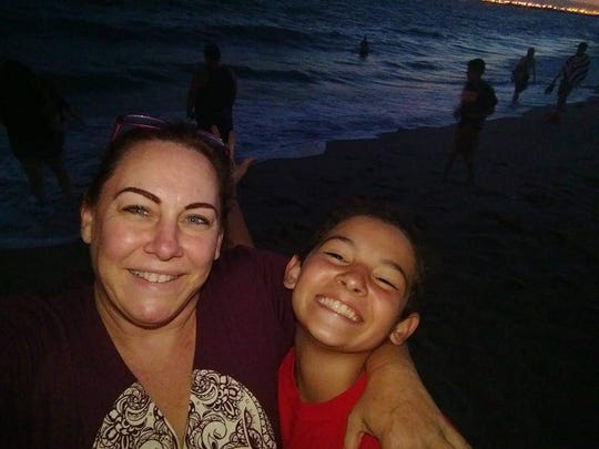 A 12-year-old Anthony Cano poses with his mom, Renee Clum, for a selfie on a beach.