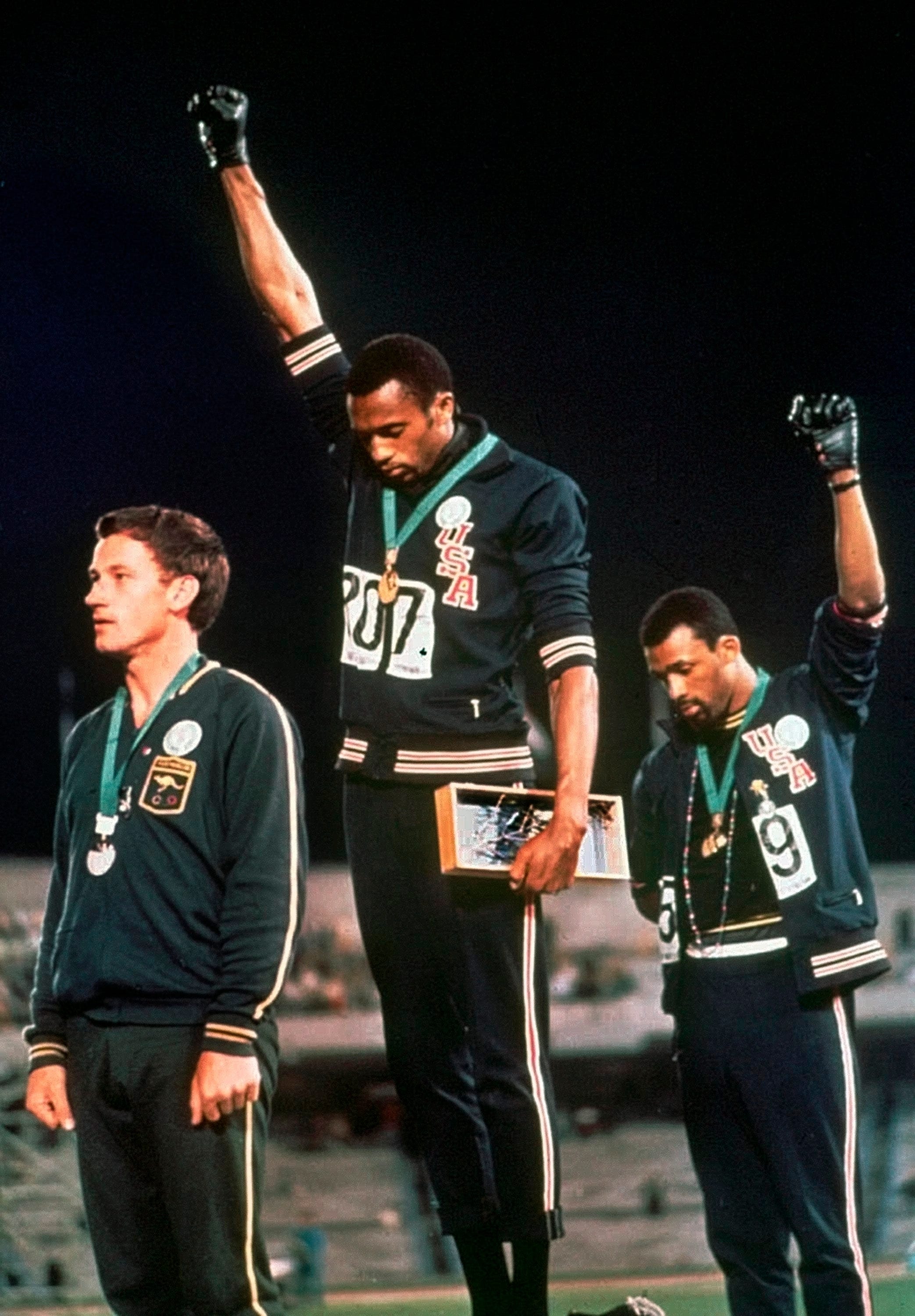 John Carlos, right, and Tommie Smith stare downward and extend gloved hands skyward in a Black Power salute at the 1968 Summer Olympics. Carlos was Jalil Muntaqim's math tutor and a mentor in high school.
