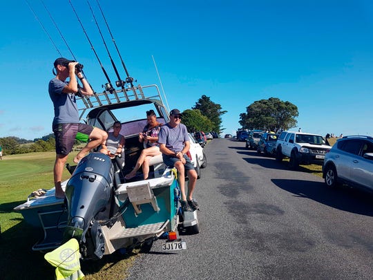 John Fitzgerald, left, scans the horizon from high ground for any sign of a tsunami on Friday near Waitangi, New Zealand.