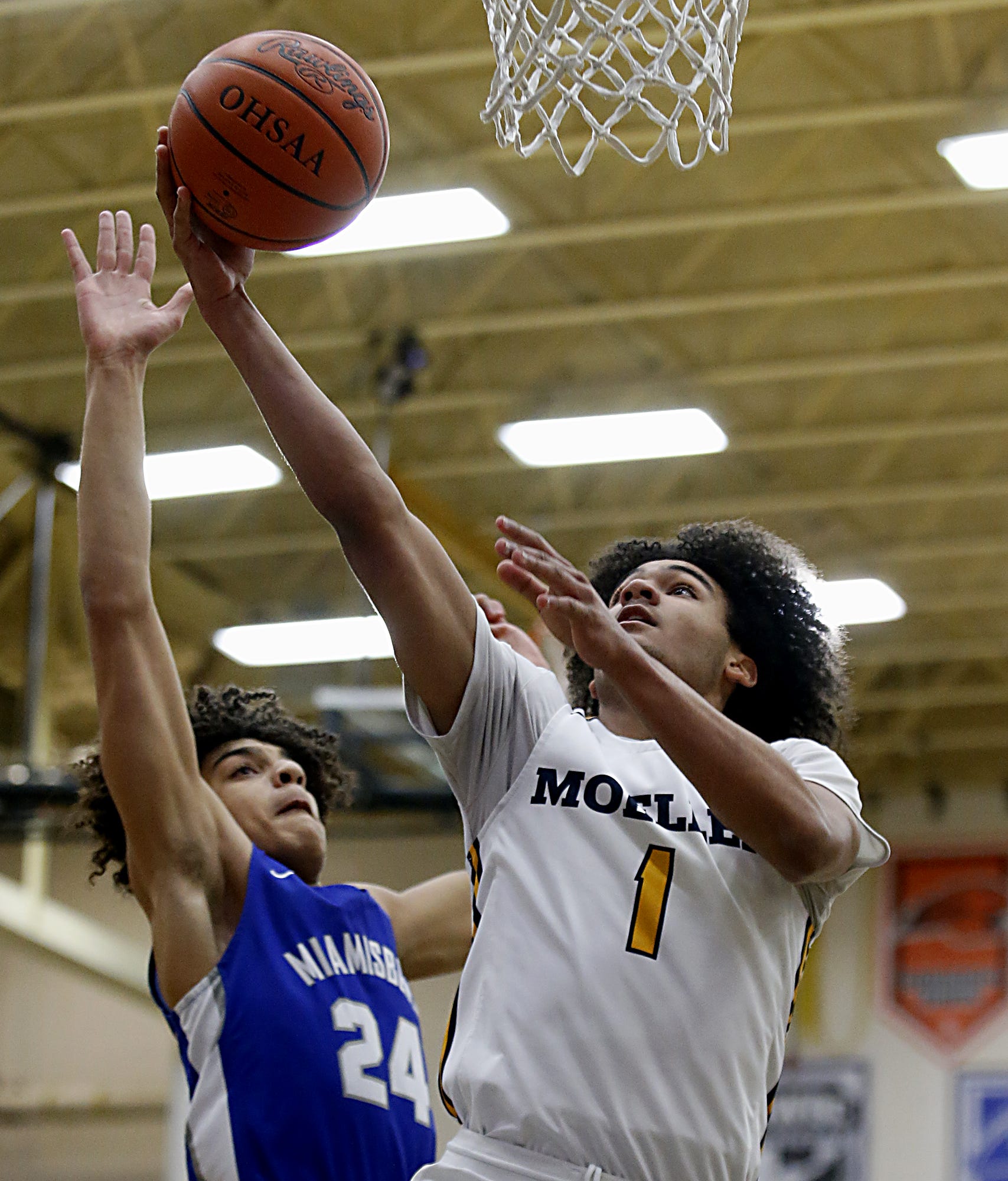Moeller High School guard Aidan Turner gets the basket against Jackson McGohan from Miamisburg during a Division I boys district final at Centerville March 6, 2021. Moeller won 75-54.