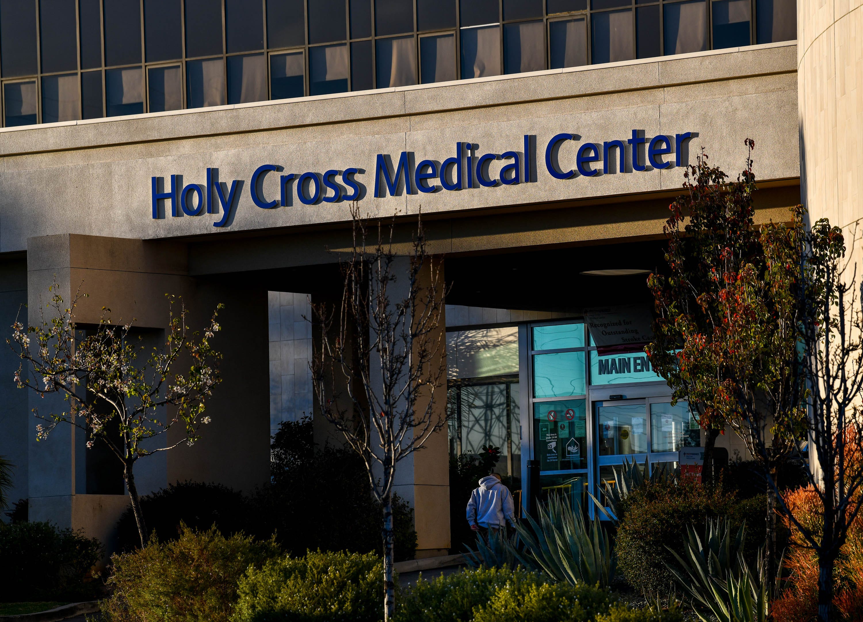 A pedestrian walks into the Providence Holy Cross Medical Center on Friday, Feb. 12, 2021, in Mission Hills, Calif.