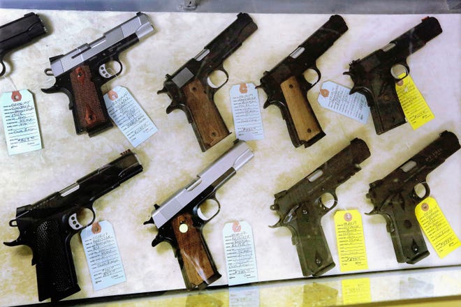 In this July 10, 2013, file photo, handguns are seen display for purchase at Capitol City Arms Supply in Springfield, Ill.