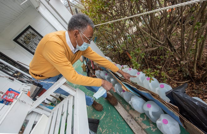 James Brooks erklärt die Gallonen Wasser auf der Veranda des Hauses in Jackson, Miss. Brooks, ein selbsternannter Wasserhorter, kennt sich mit Wasserproblemen in der Stadt Jackson bestens aus. Er hat immer Wasser gespart, erklärt er. Es dauert eine volle Minute, bis sein heißes Wasser heiß wird