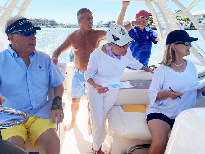 The Yacht Club team onboard Team “Lady B” scan the shoreline in Smokehouse Bay, looking for a dock with five colorful chairs. The contest consisted 55 cryptic clues that teams had to identify and photograph on the shore in five different zones. Pictured, from left: Jeff Comeaux, Scot Ruhlander, Ginny Colangelo, Bob Colangelo, Carol Comeaux.
