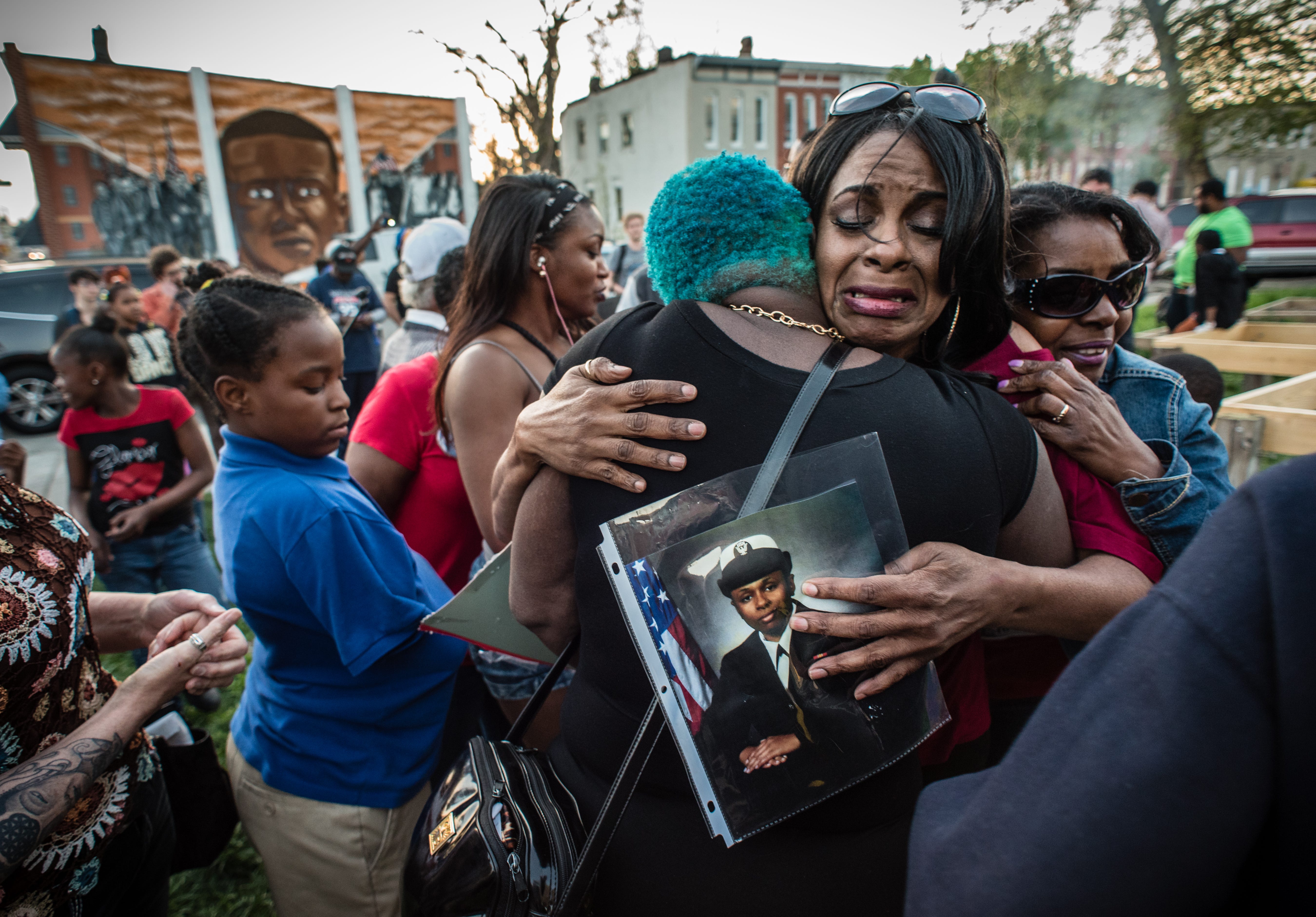 Activist Gina Best, weeps after speaking to an assembly on April 19, 2016 in Baltimore about her daughter, India Kager, who was killed by police in Virginia Beach. She's embraced by friends, supporters and residents after her emotional testimony.