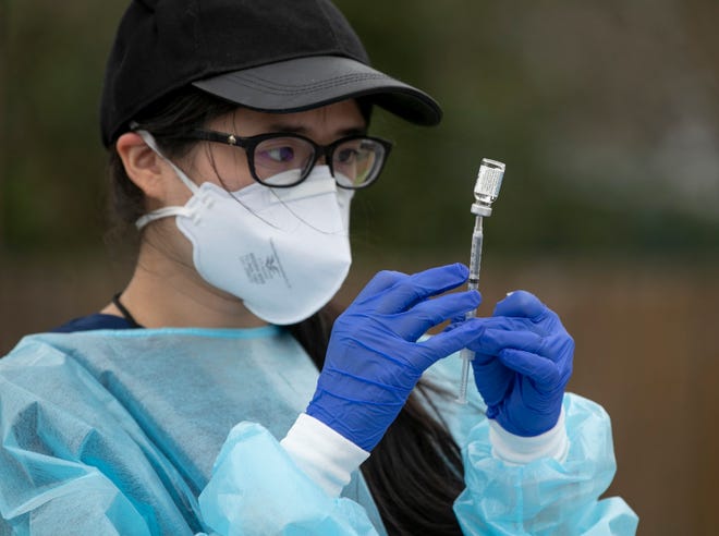 Pharmacist Emily Chu prepares a Johnson & Johnson COVID-19 vaccine at a drive-through vaccine clinic at Woodlawn Baptist Church in South Austin on March 10. [AMERICAN-STATESMAN/FILE]