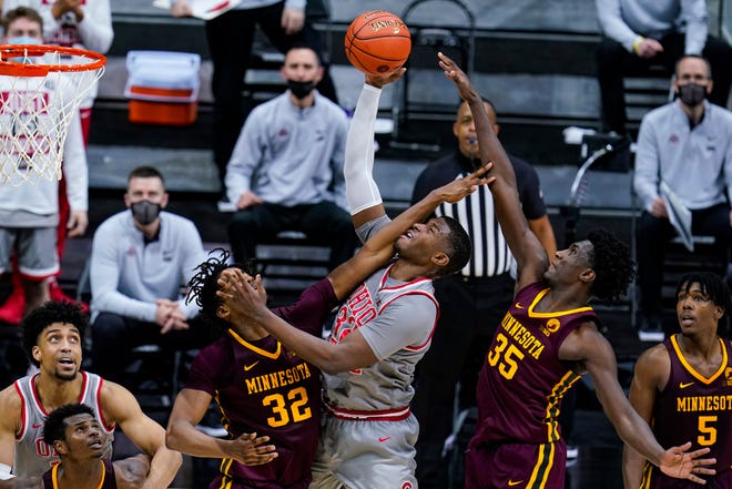 Ohio State forward E.J. Liddell (32) shoots between Minnesota center Sam Freeman (32) and forward Isaiah Ihnen (35) in the second half of an NCAA college basketball game at the Big Ten Conference tournament in Indianapolis, Thursday, March 11, 2021. (AP Photo/Michael Conroy)