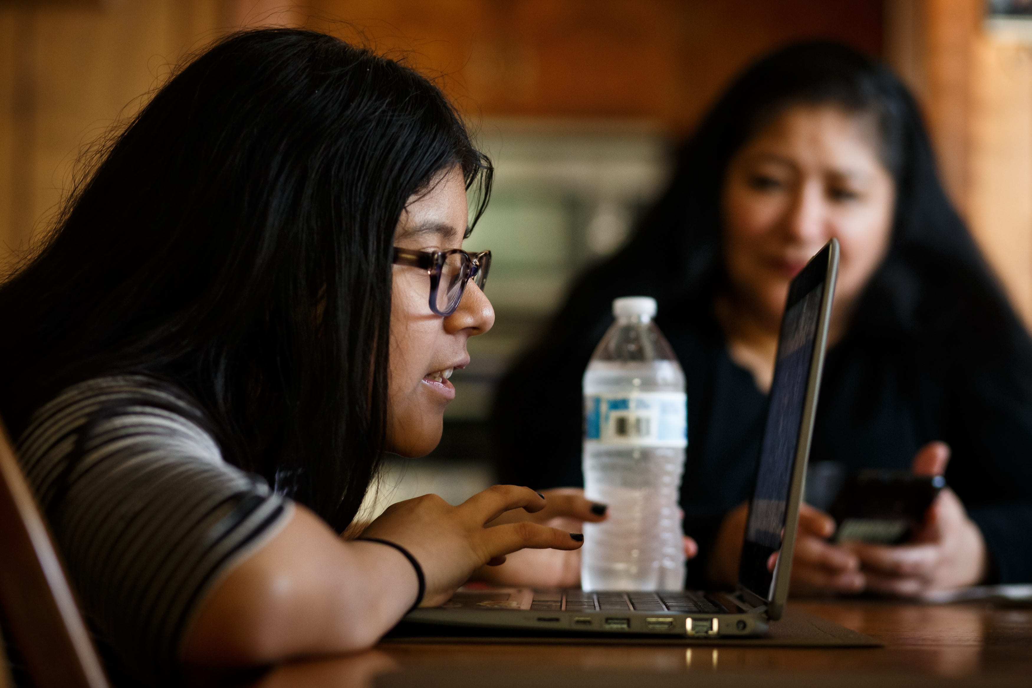 Getting in close to see all the people who have joined her Big Brothers Big Sisters Zoom call, Kiara Juarez, 11, introduces herself as her mother, Brenda Rodriguez, looks on from their dining room on March 3, 2021, in Des Moines.