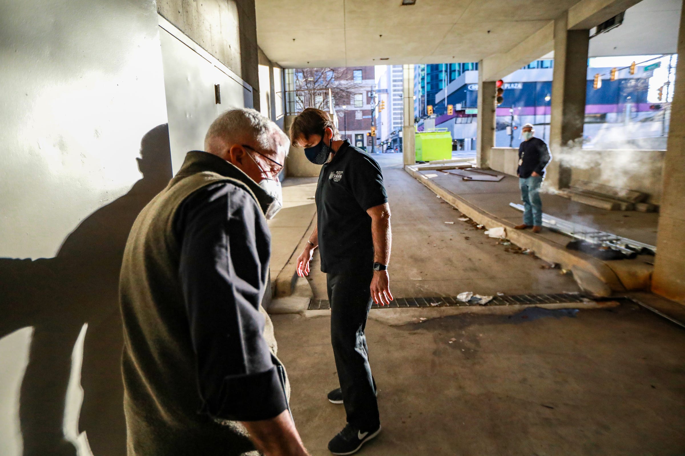 Ford Motor Co, CEO Jim Farley, right, gets a tour of the shower facilities from Fr. Tim McCabe, S.J. at the Pope Francis Center that sits in a loading dock outside TCF Center in downtown Detroit on SMarch 6, 2021.