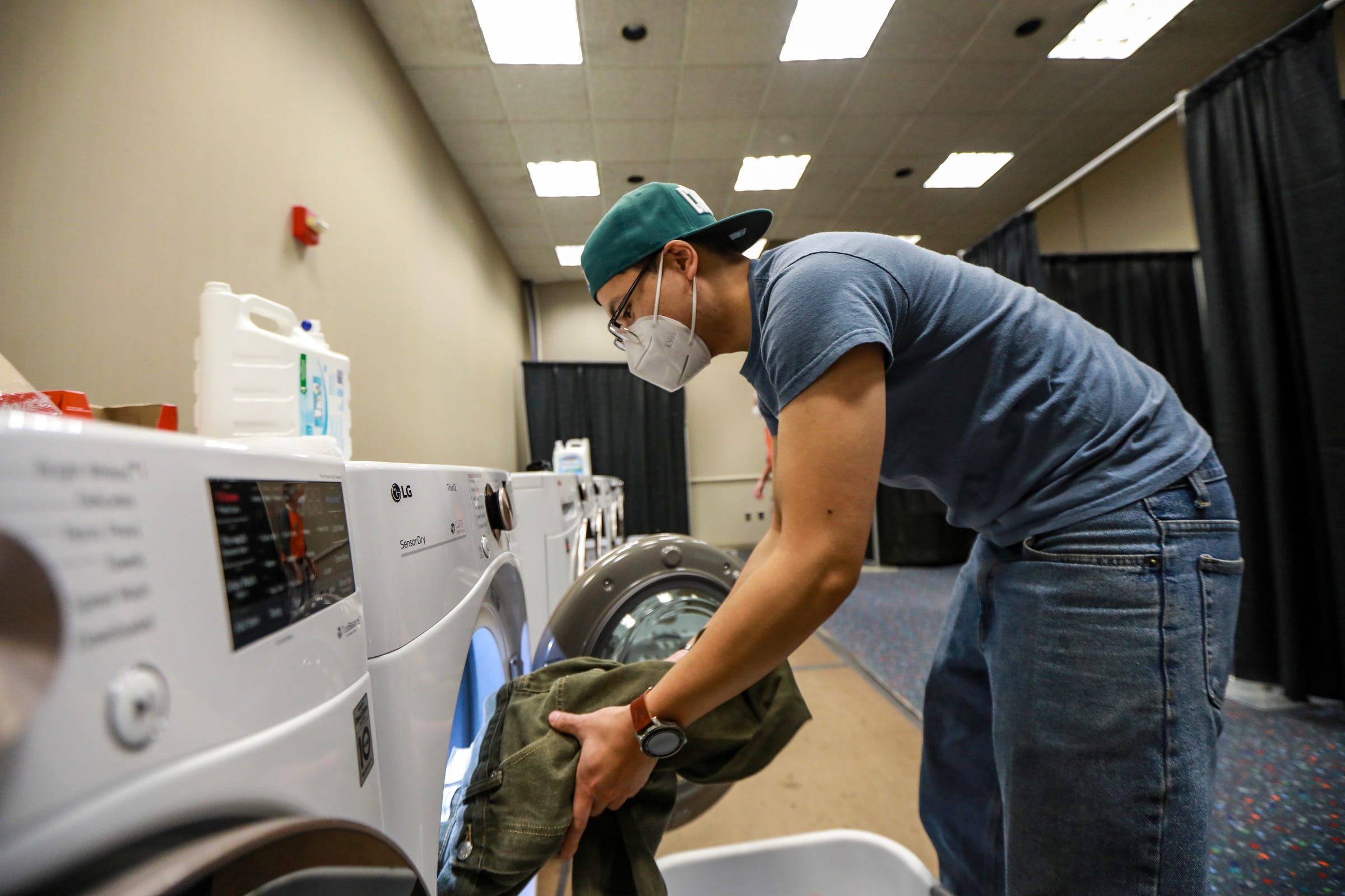 Boratha Tan, 27, of Detroit volunteers in the laundry room at the Pope Francis Center in TCF Center in downtown Detroit on March 6, 2021. Tan has been volunteering at Pope Francis Center for five years and is an engineer at Ford Motor Co. Dearborn campus.